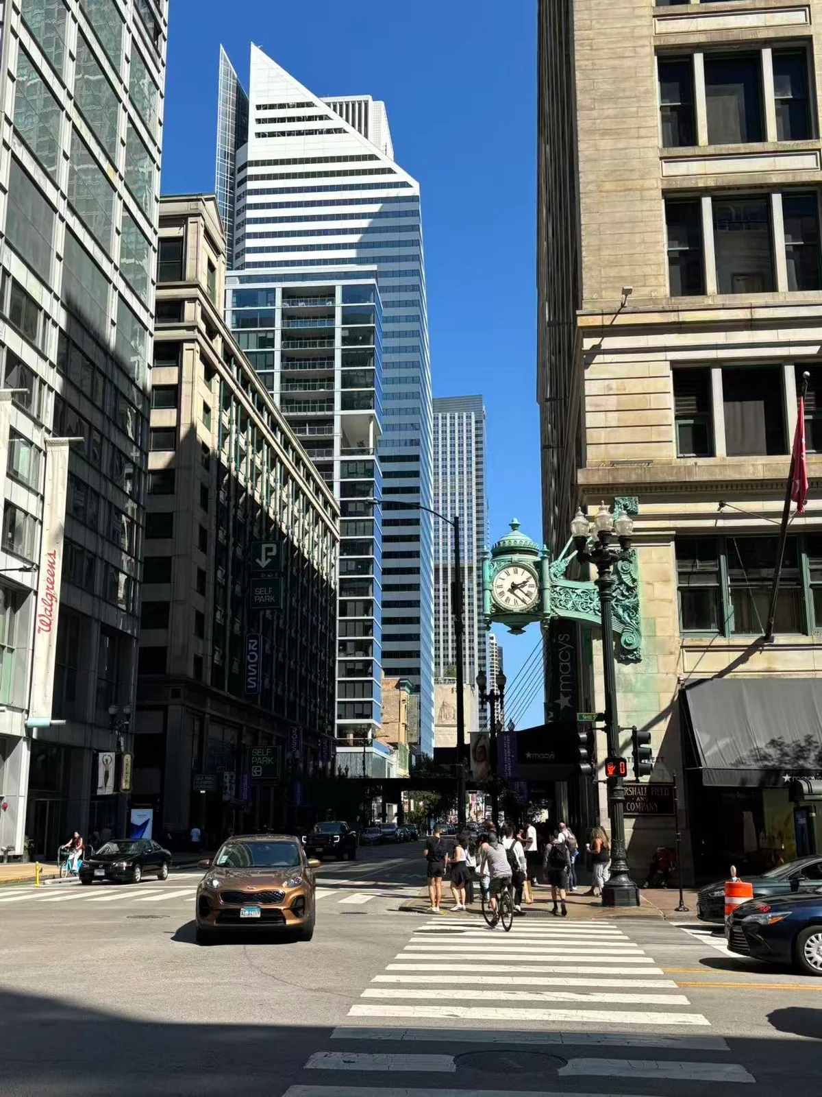 A Chicago street framed by tall buildings beneath a clear blue sky
