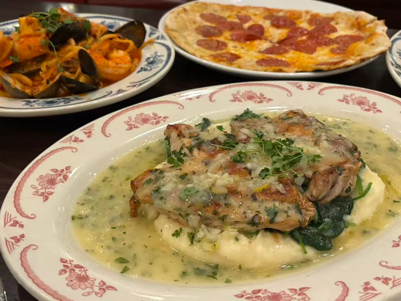 A plate of food served alongside other dishes on a restaurant table