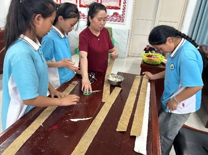 Students and a volunteer working together with wooden strips at a table